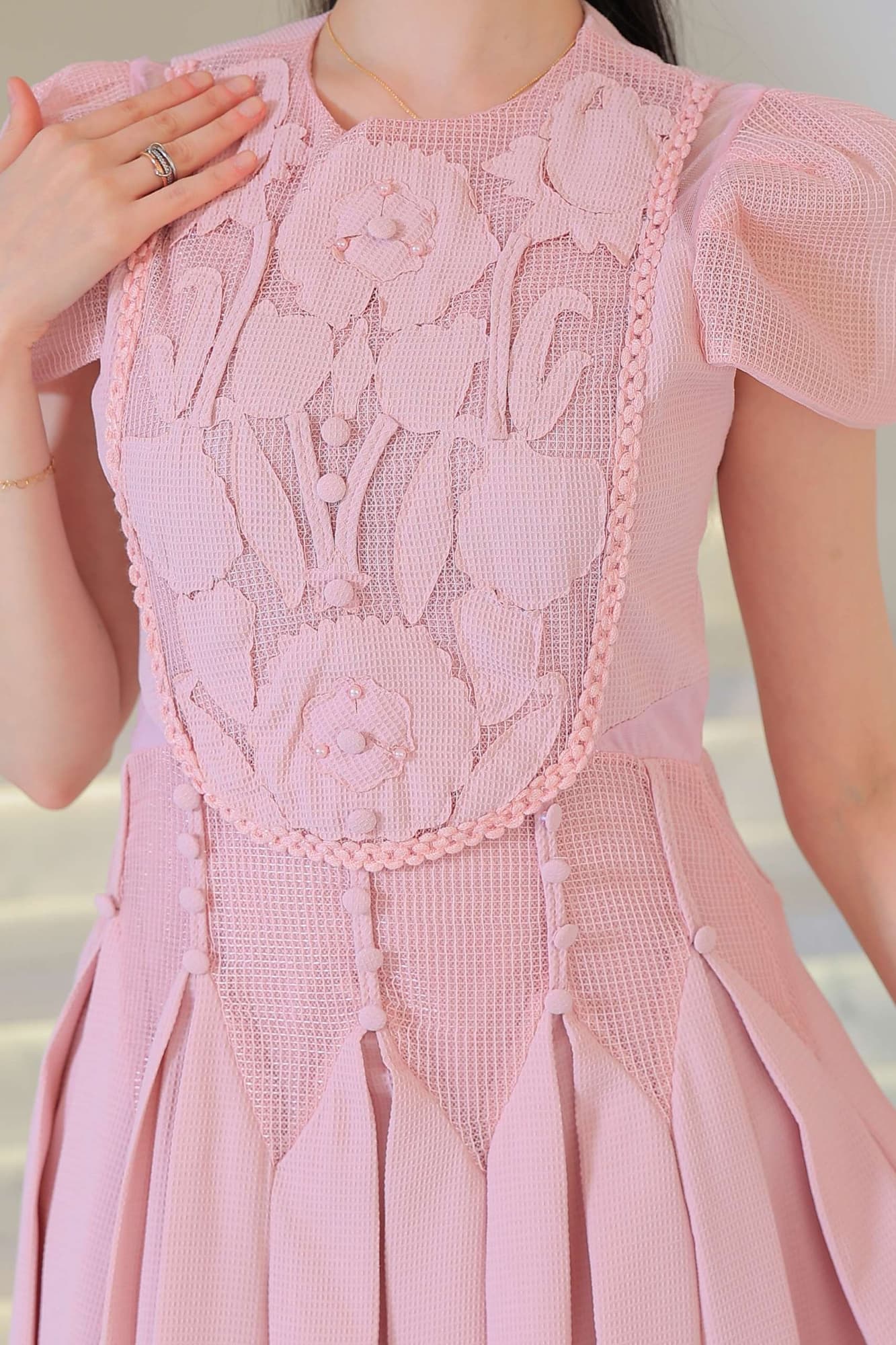 فستان أنيق بطابع ناعم وأنثوي يتميز بتفاصيل دانتيل وزخارف بارزة