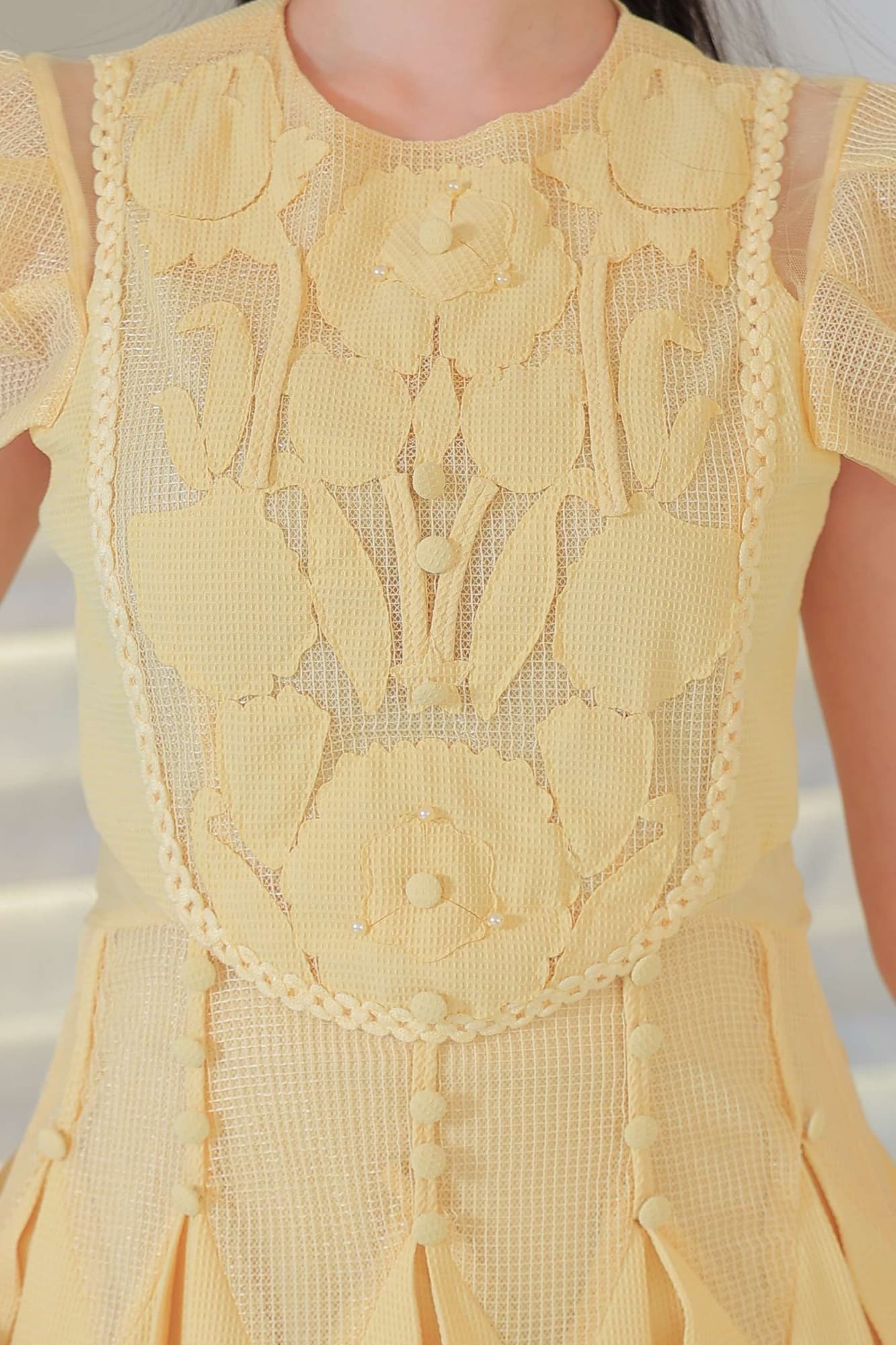 فستان أنيق بطابع ناعم وأنثوي يتميز بتفاصيل دانتيل وزخارف بارزة