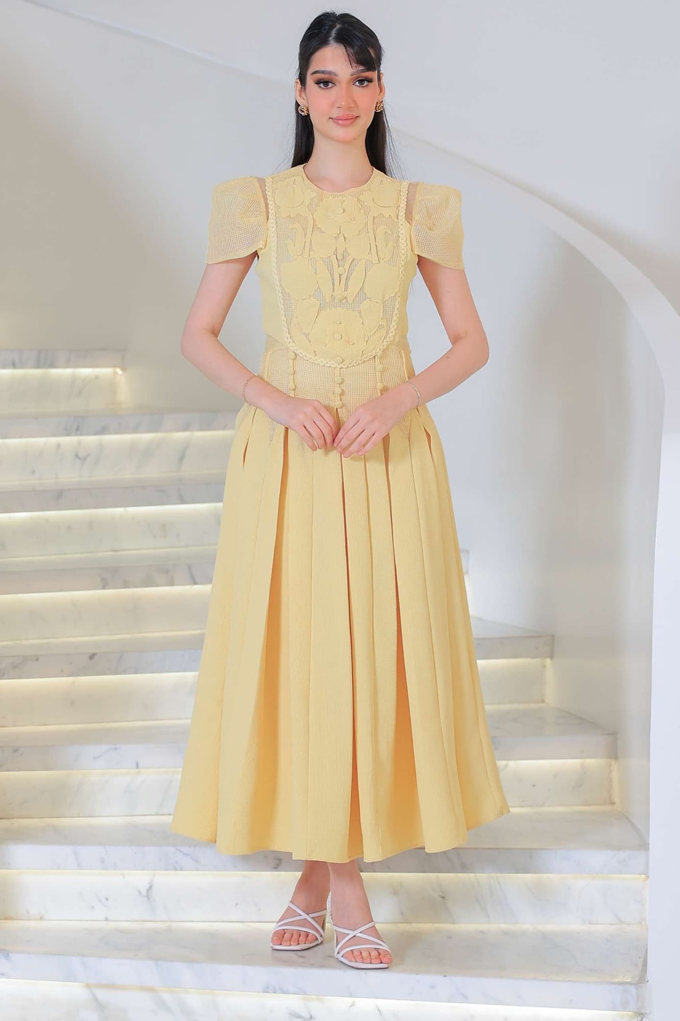 فستان أنيق بطابع ناعم وأنثوي يتميز بتفاصيل دانتيل وزخارف بارزة