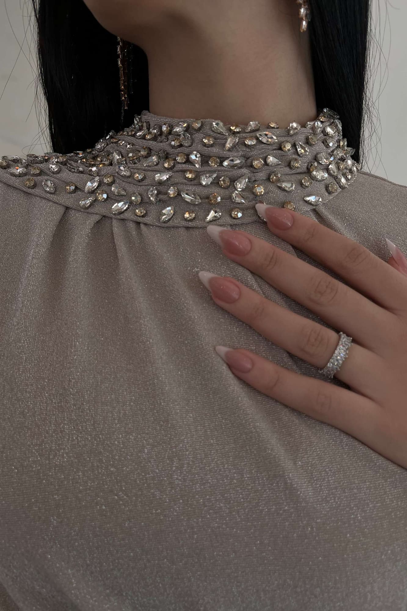 فستان طويل يجسّد الفخامة الهادئة، بلون بيج دافئ بلمعة ناعمة تعكس الضوء برقي