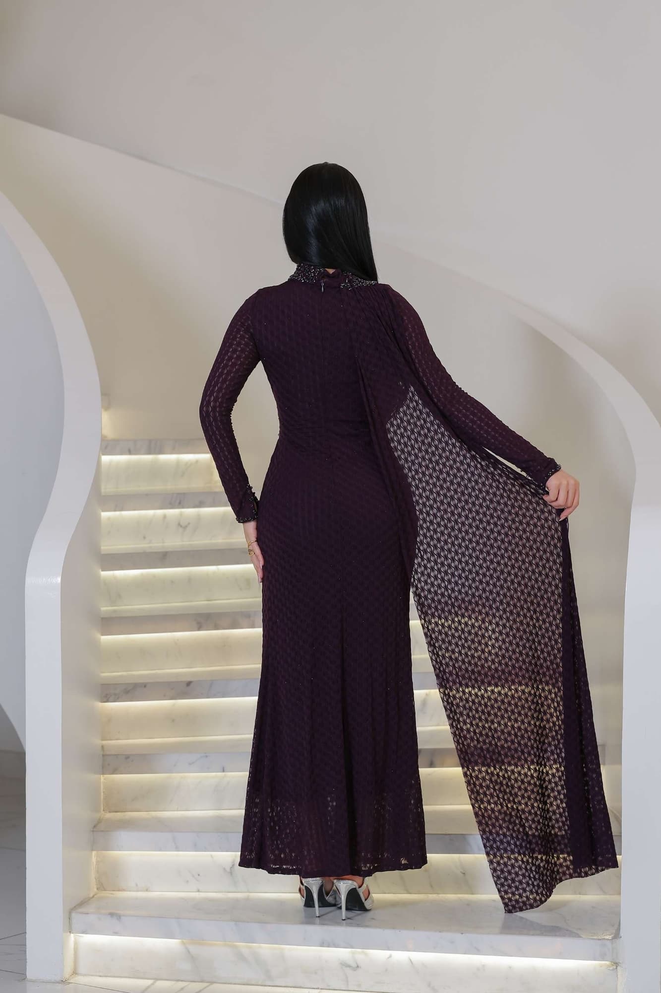 فستان ناعم راقٍ يتميّز بياقة عالية مزينة بتطريز خرزي ناعم يضفي لمسة ملكية