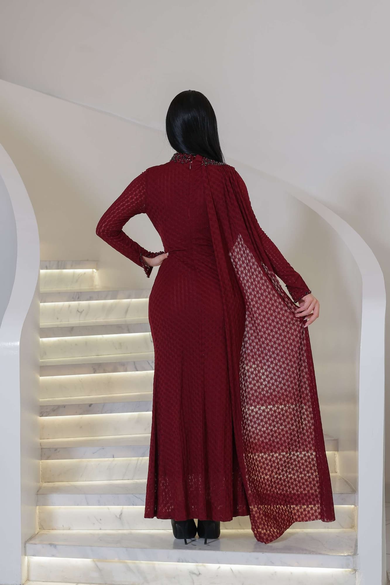 فستان ناعم راقٍ يتميّز بياقة عالية مزينة بتطريز خرزي ناعم يضفي لمسة ملكية