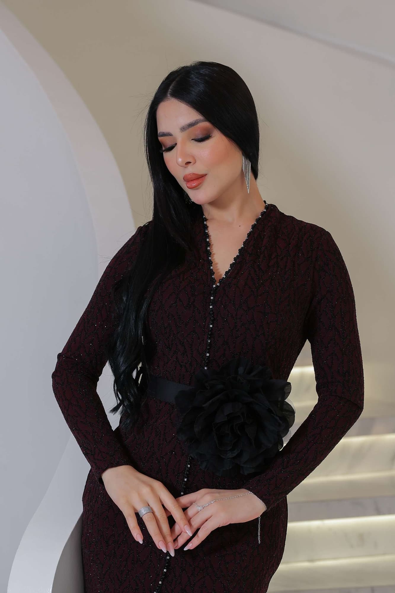 فستان أنيق مصنوع من قماش مطرّز بنقشة ناعمة مزين بتفاصيل دقيقة تمتد طوليًا حتى أسفل الفستان