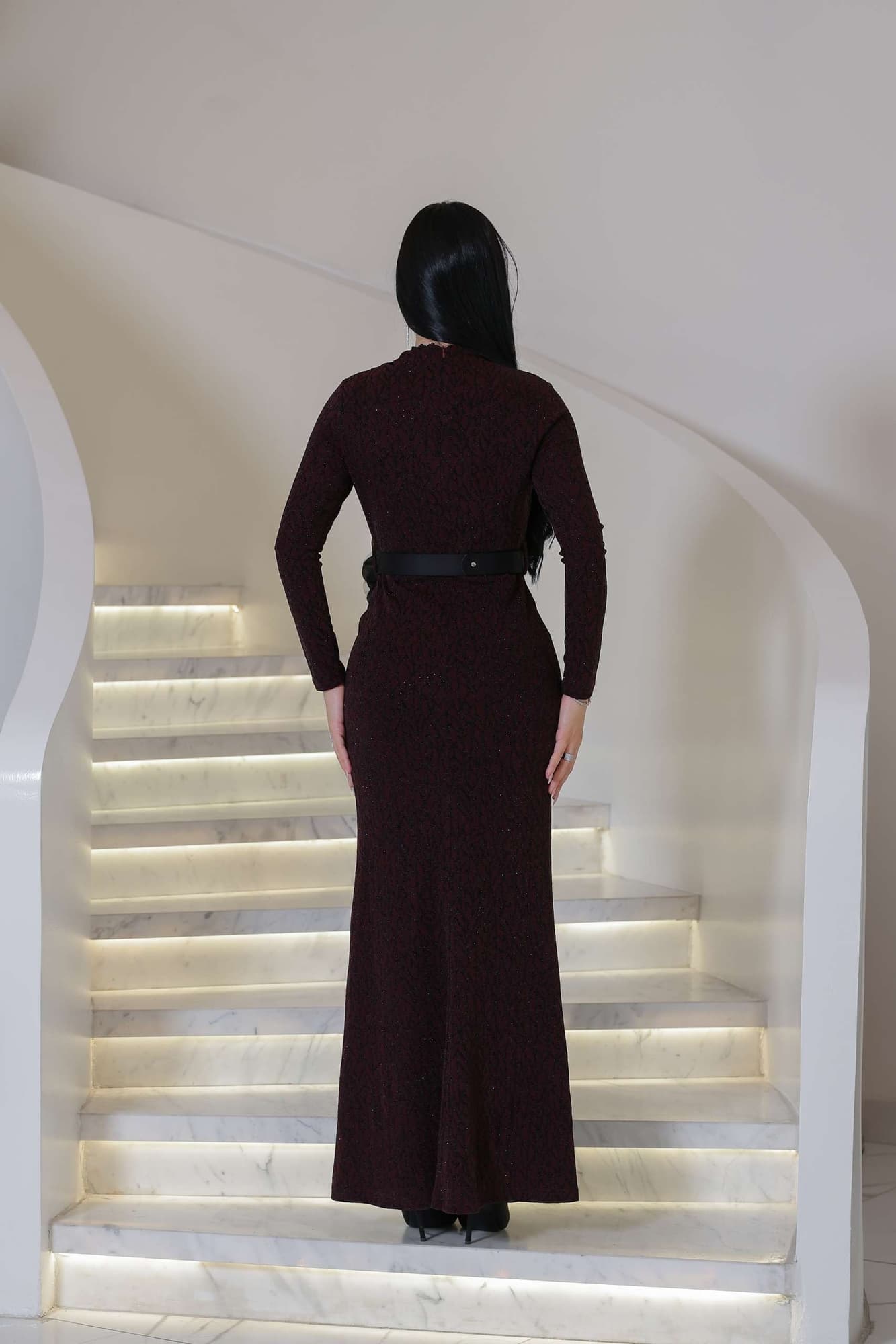 فستان أنيق مصنوع من قماش مطرّز بنقشة ناعمة مزين بتفاصيل دقيقة تمتد طوليًا حتى أسفل الفستان