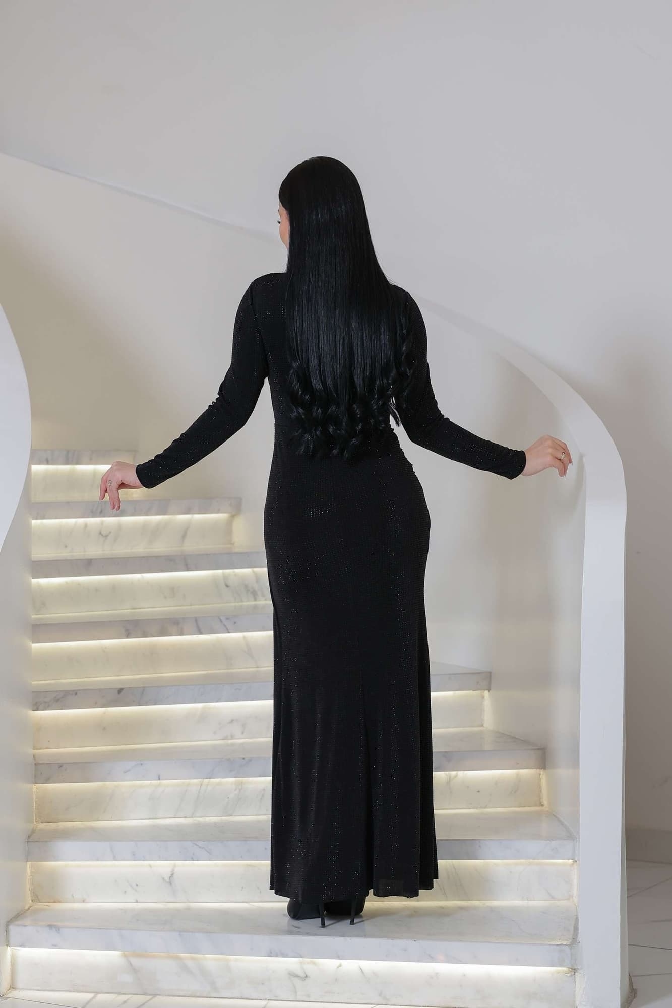 فستان ناعم طويل مصنوع من قماش ناعم بلمعة خفيفة تمنح إطلالة أنيقة وراقية