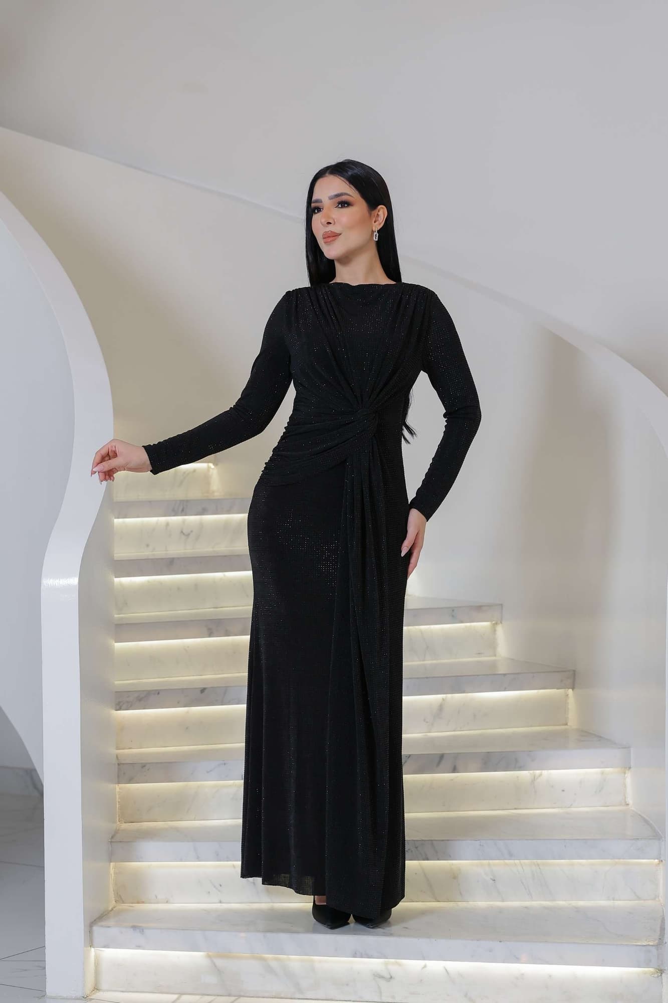 فستان ناعم طويل مصنوع من قماش ناعم بلمعة خفيفة تمنح إطلالة أنيقة وراقية