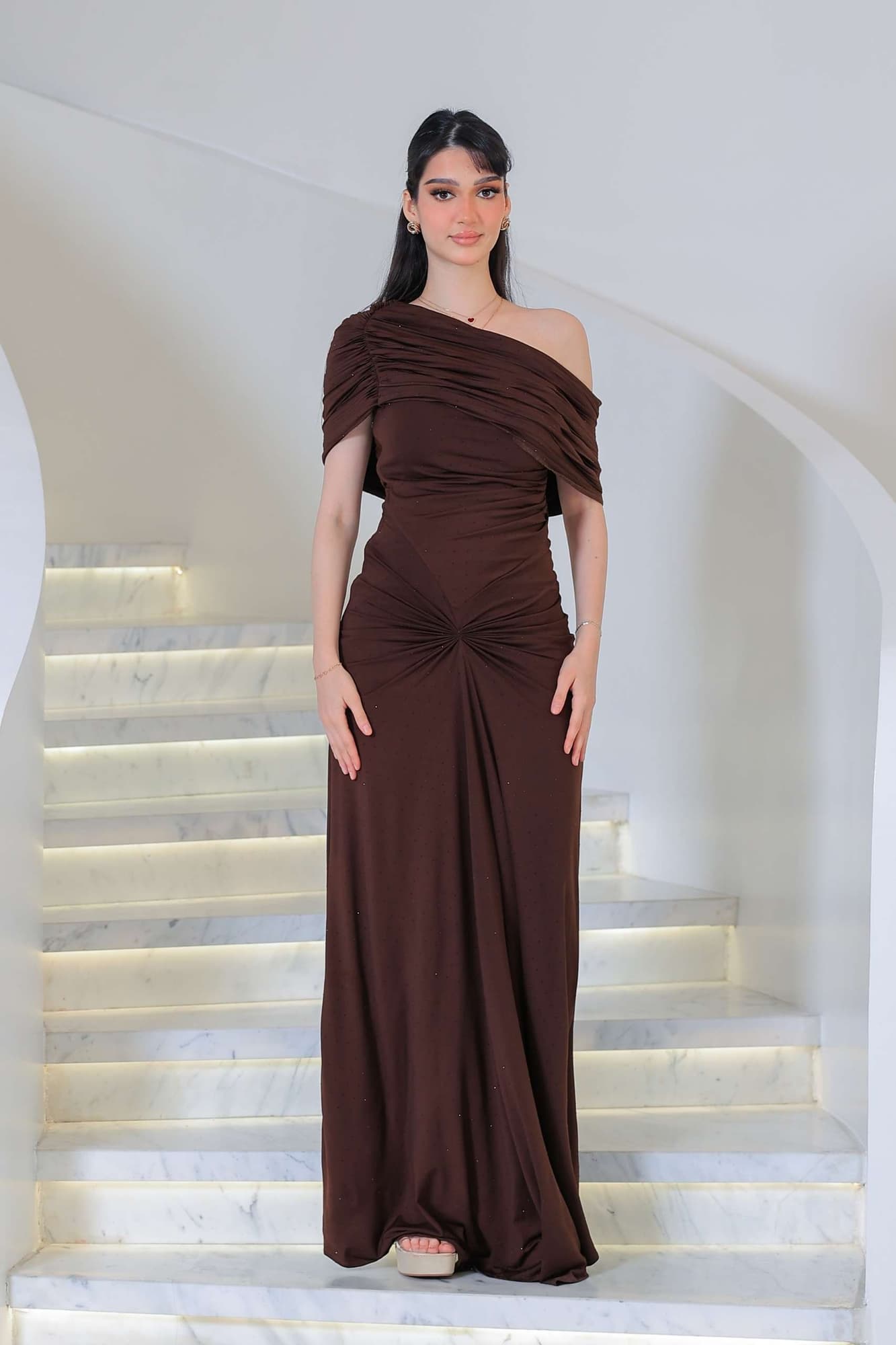 فستان أنيق يجمع بين الرقي والبساطة مزين بفصوص يتميز بانسداله الناعم على القوام