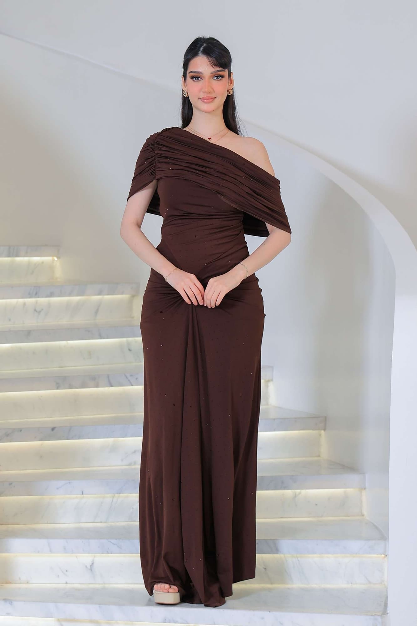 فستان أنيق يجمع بين الرقي والبساطة مزين بفصوص يتميز بانسداله الناعم على القوام