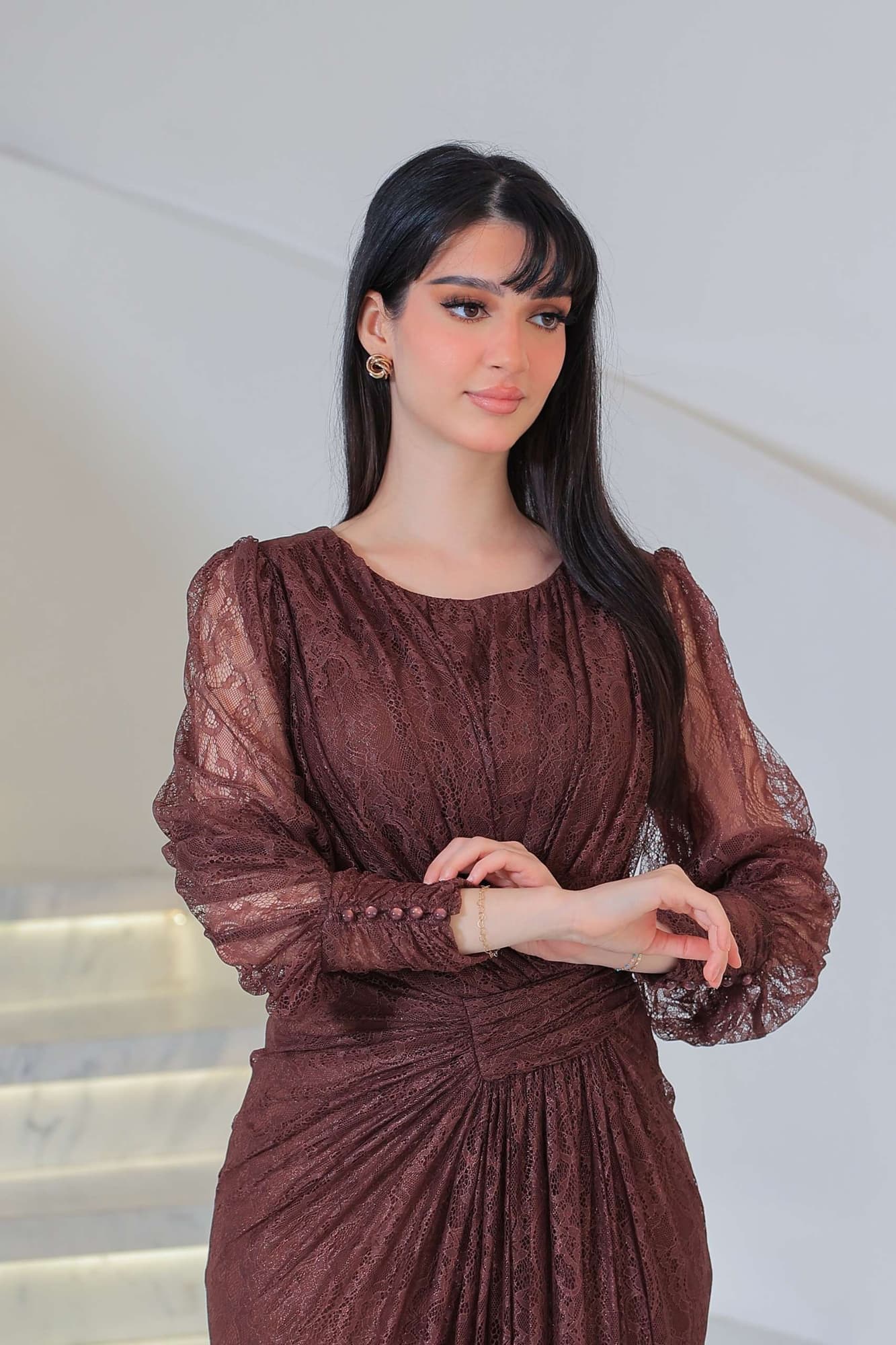 فستان دانتيل طويل يتميز بتفاصيل draping ملتفة حول منطقة الخصر تنحت الجسم بأسلوب أنثوي