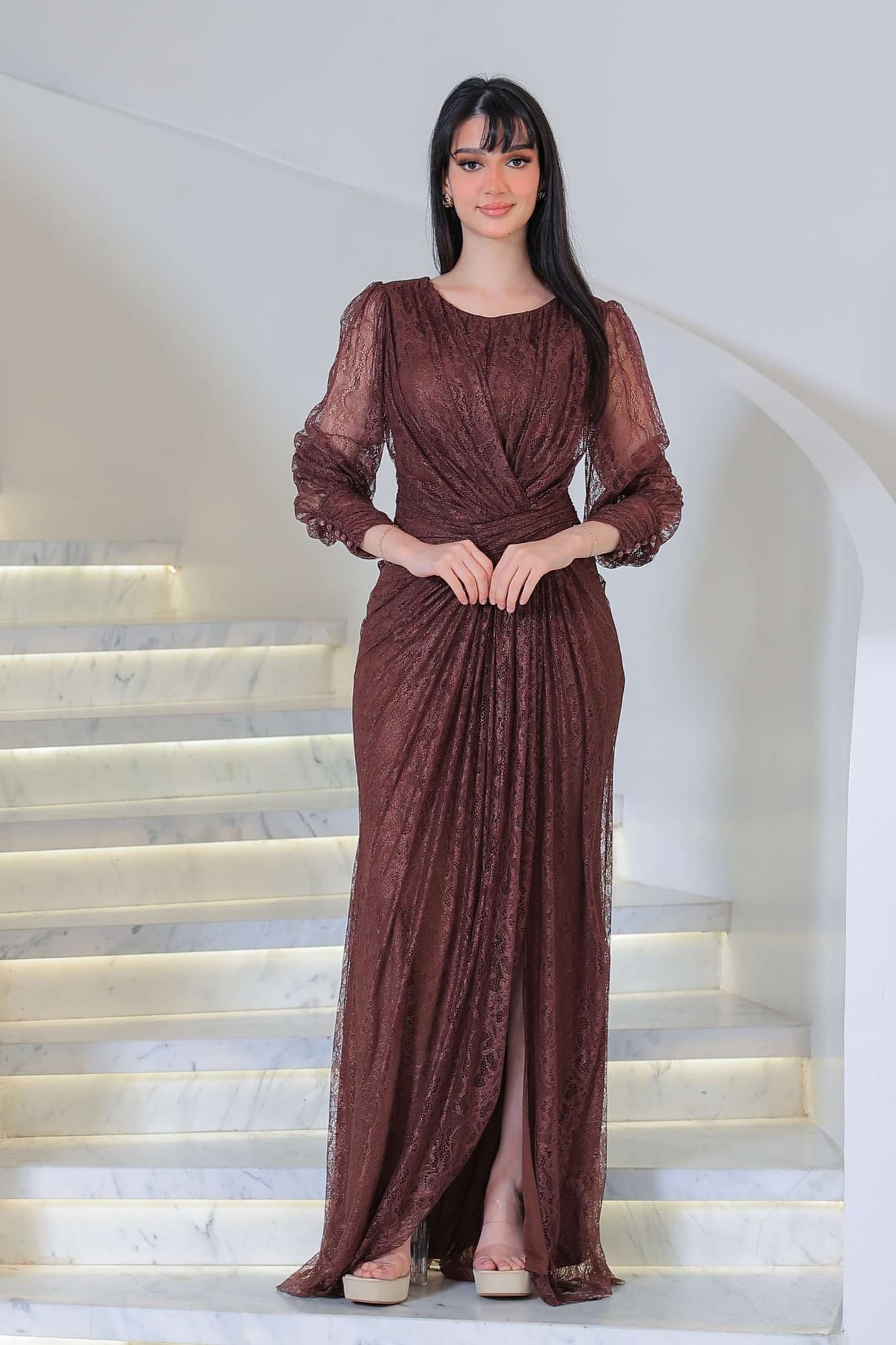 فستان دانتيل طويل يتميز بتفاصيل draping ملتفة حول منطقة الخصر تنحت الجسم بأسلوب أنثوي