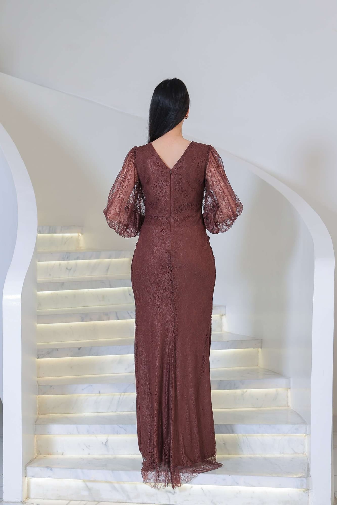 فستان دانتيل طويل يتميز بتفاصيل draping ملتفة حول منطقة الخصر تنحت الجسم بأسلوب أنثوي