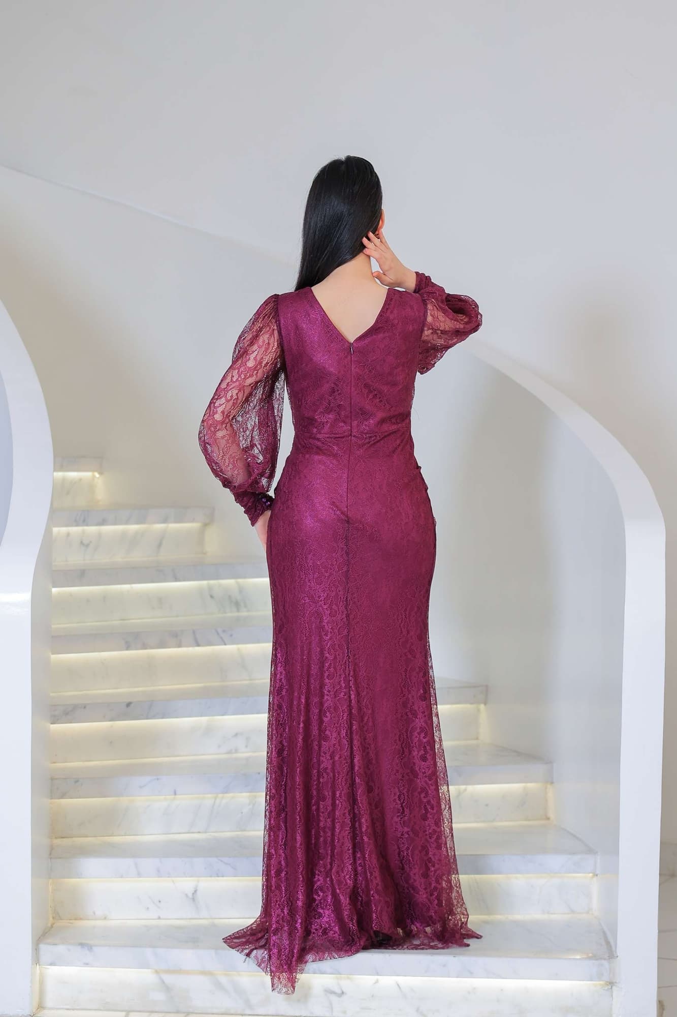 فستان دانتيل طويل يتميز بتفاصيل draping ملتفة حول منطقة الخصر تنحت الجسم بأسلوب أنثوي