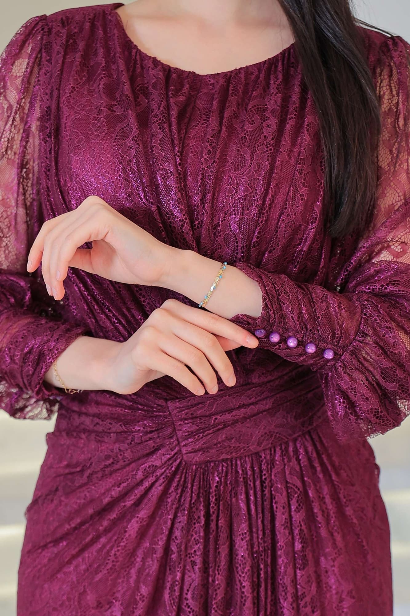 فستان دانتيل طويل يتميز بتفاصيل draping ملتفة حول منطقة الخصر تنحت الجسم بأسلوب أنثوي