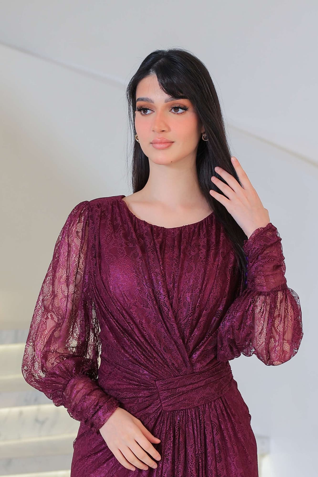 فستان دانتيل طويل يتميز بتفاصيل draping ملتفة حول منطقة الخصر تنحت الجسم بأسلوب أنثوي