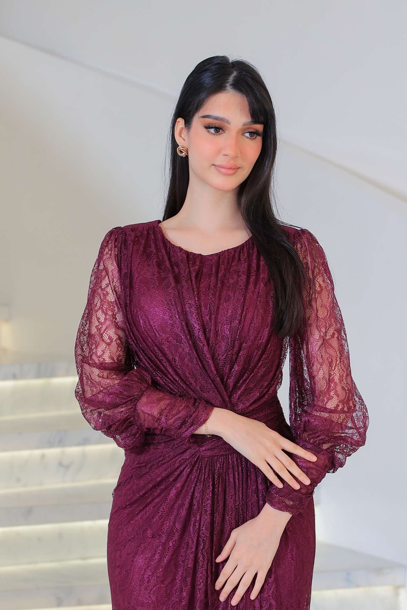 فستان دانتيل طويل يتميز بتفاصيل draping ملتفة حول منطقة الخصر تنحت الجسم بأسلوب أنثوي