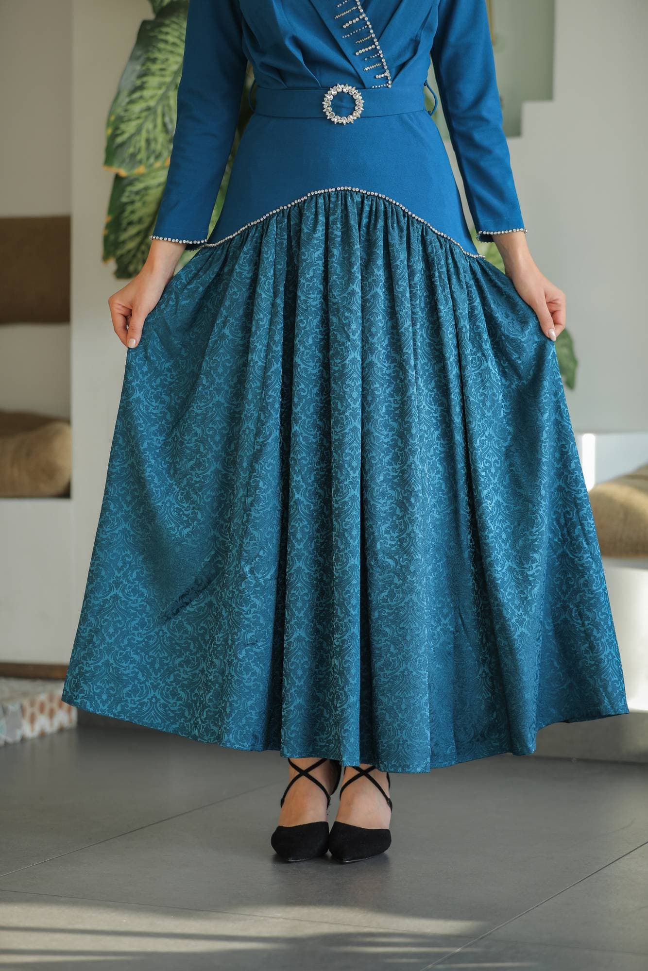 فستان راقٍ بلون أخضر زمردي عميق يجمع بين الكلاسيكية والفخامة بأسلوب عصري