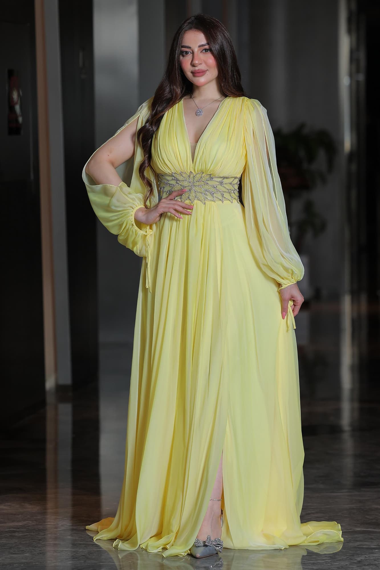 فستان ساحر بلون الليمون الهادئ يجمع بين النعومة والفخامة في تصميم انسيابي يخطف الأنظار