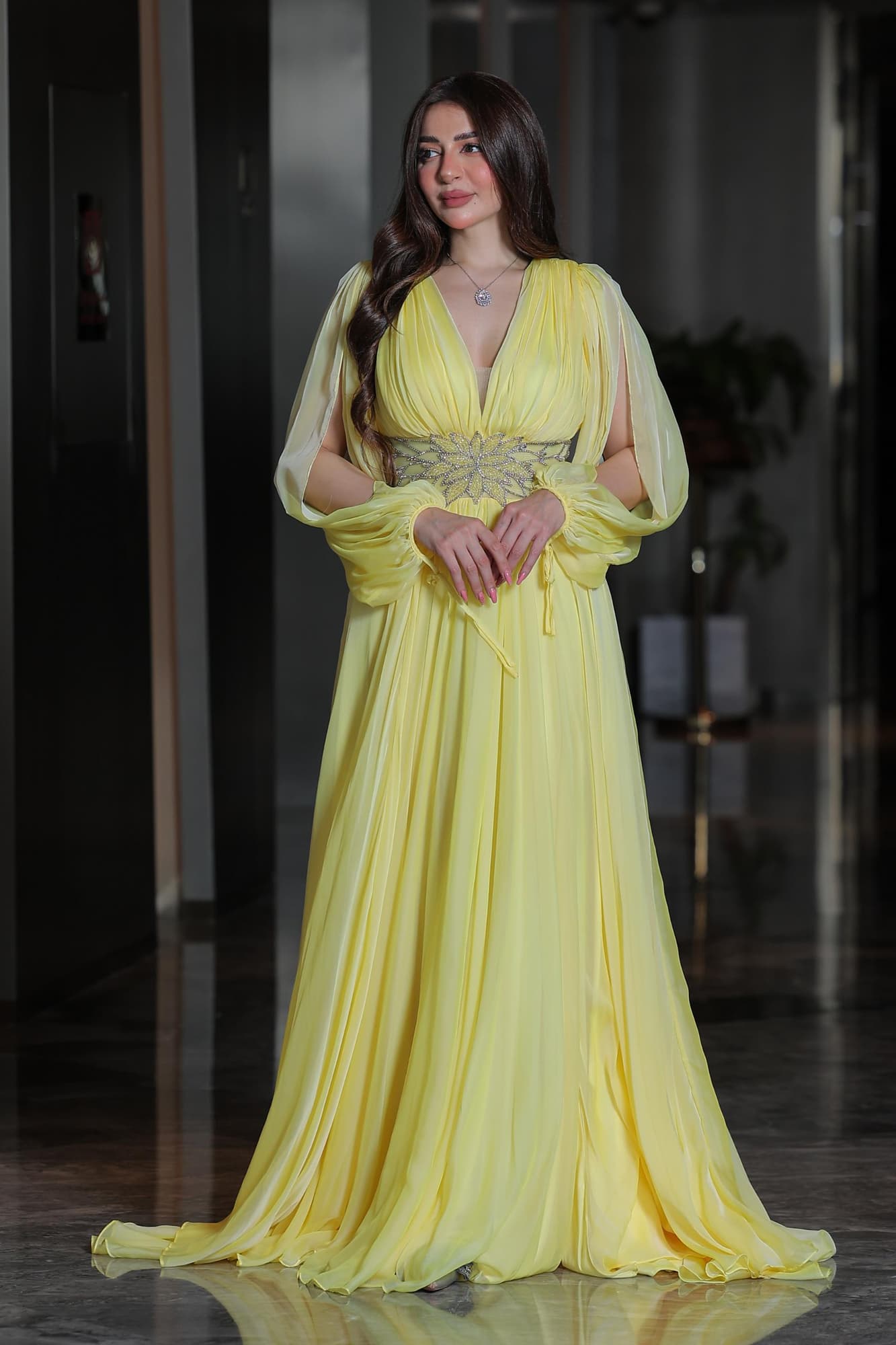 فستان ساحر بلون الليمون الهادئ يجمع بين النعومة والفخامة في تصميم انسيابي يخطف الأنظار