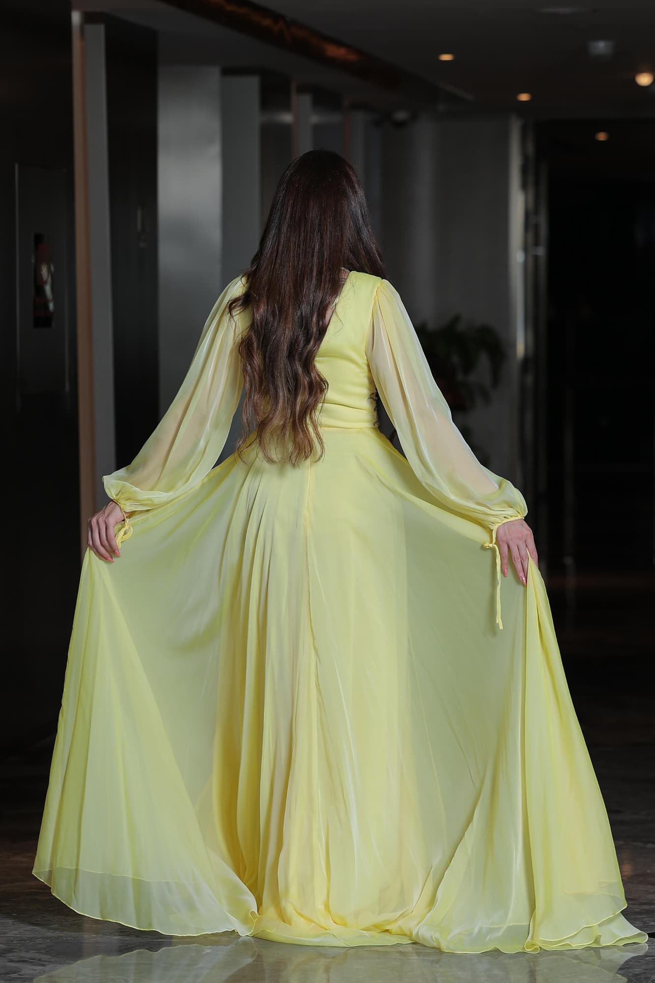 فستان ساحر بلون الليمون الهادئ يجمع بين النعومة والفخامة في تصميم انسيابي يخطف الأنظار